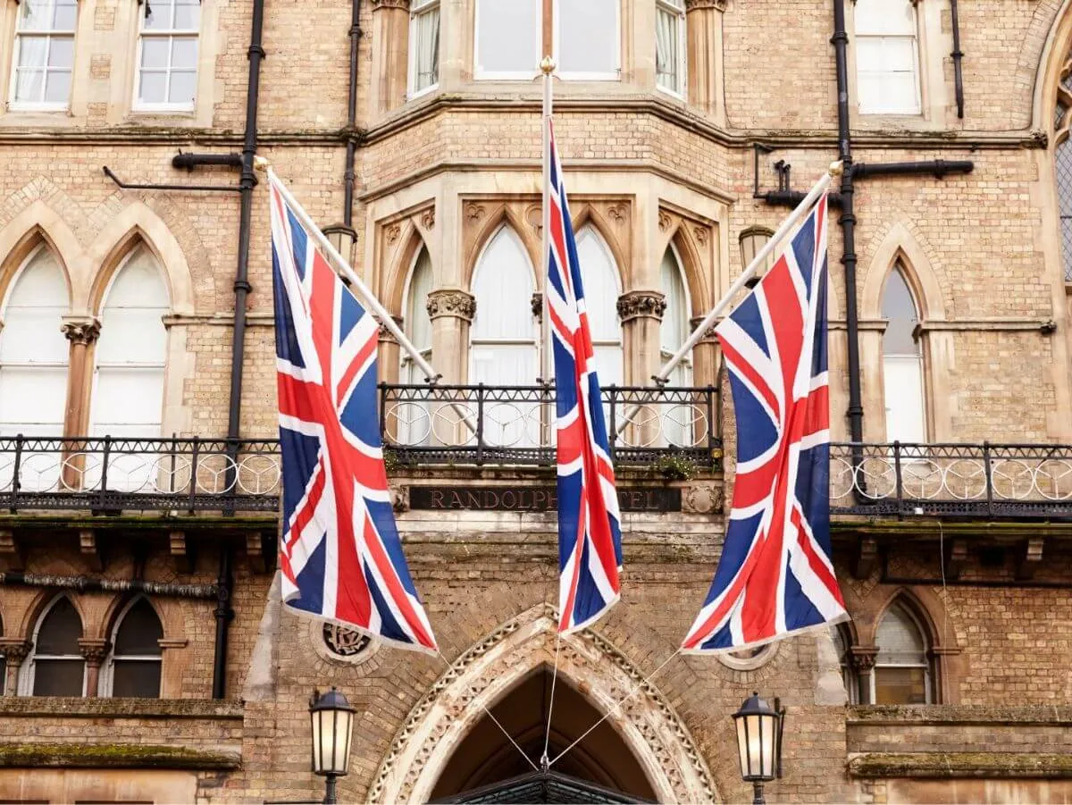 Drapeaux de l'Union Jack suspendus à l'extérieur d'un bâtiment, créant une ambiance festive et patriotique.