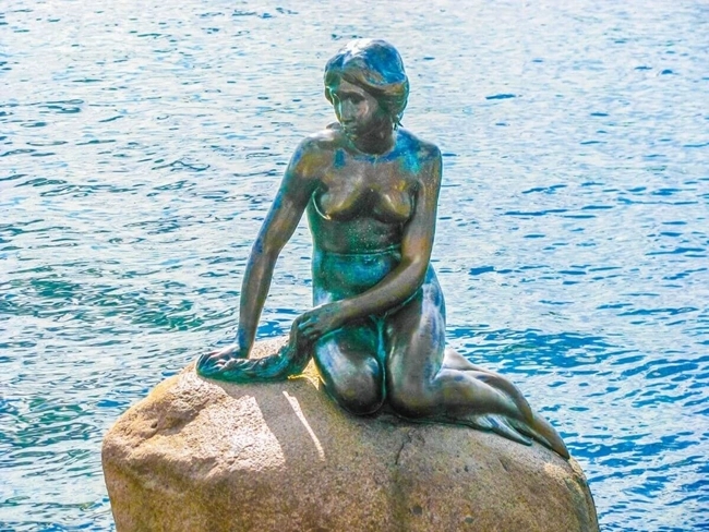 Statue de la Petite Sirène à Copenhague, emblématique et délicate, surplombant le port avec grâce et beauté.